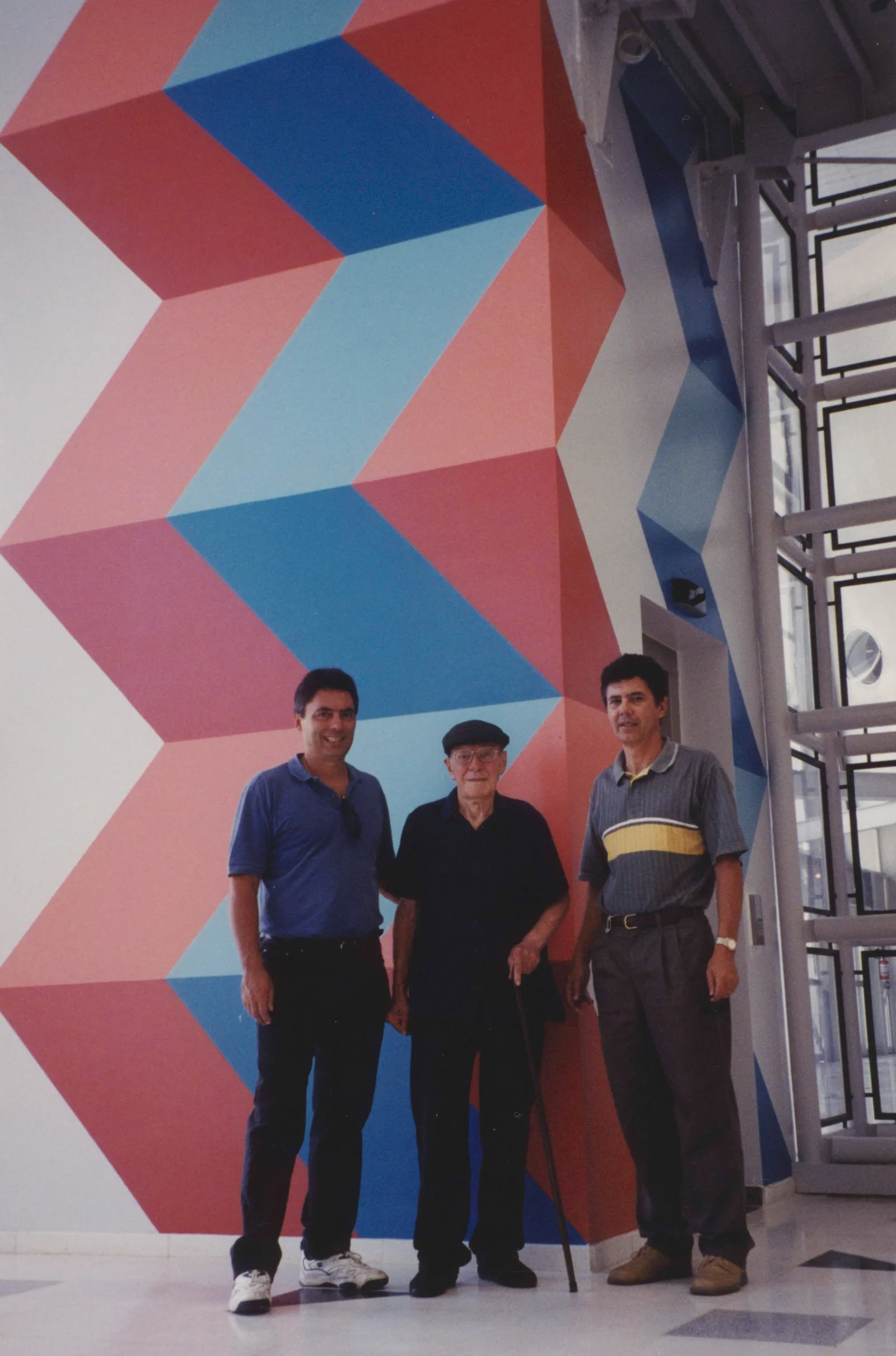 Sacilotto com os filhos Oscar e Valter em frente ao painel do Sesc Santo André, 2002